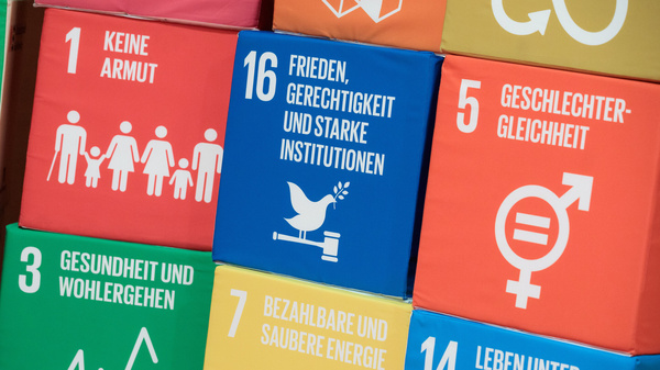 Globale Nachhaltigkeitsziele (SDG) Mehrere Würfel mit Aufdrucken von globalen Nachhaltigkeitszielen sind über- und nebeneinander gestapelt.