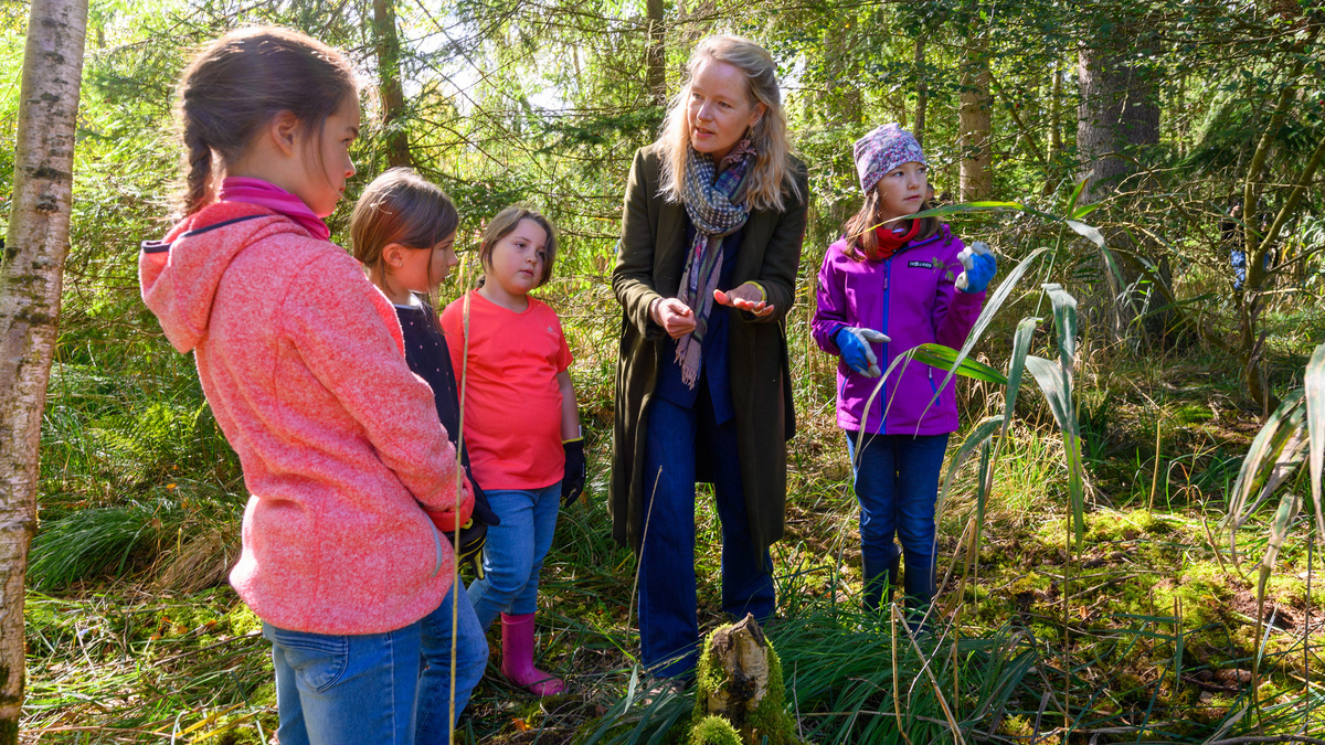 Umweltministerin Thekla Walker redet mit einigen Kindern im Moor bei Bad Dürrheim.