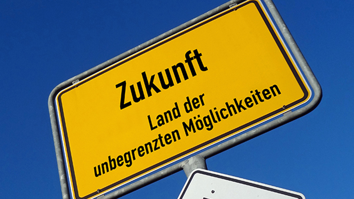 Ein Ortseingangsschild vor einem dunkelblauen Himmel trägt statt eines Ortsnamens die Aufschrift "Zukunft, Land der unbegrenzten Möglichkeiten"..