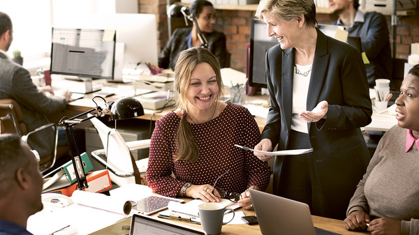 Dargestellt sind Angestellte in einem Großraumbüro.
