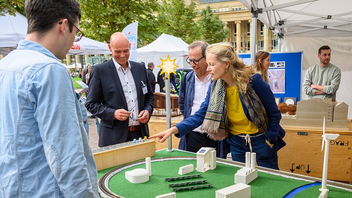 Thekla Walker, Ministerin für Umwelt, Klima und Energiewirtschaft, steht mit drei Männern an einem Tisch, auf dem ein Stadtmodell aufgebaut ist.