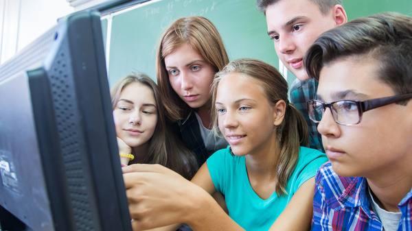 Gemeinsam Wissen erarbeiten Drei Schülerinnen und zwei Schüler drängen sich um eine Computer und schauen gespannt auf den Bildschirm.