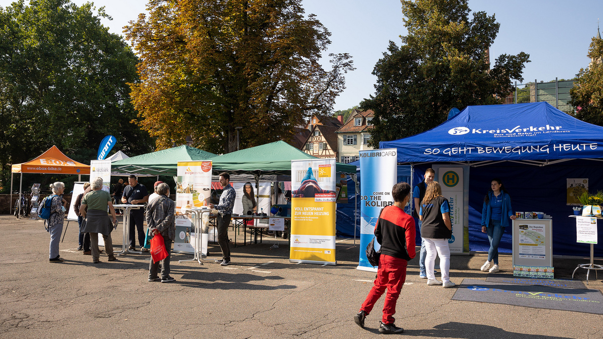 Eine Reihe von Informationsständen auf einem Markplatz empfangen interessierte Bürgerinnen und Bürger.