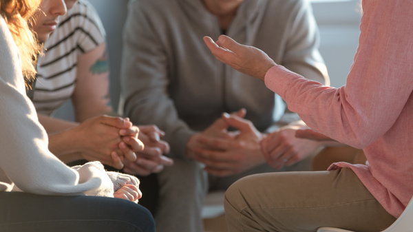 Eine Gruppe Menschen unterhält sich, dabei sind nur Hände zu sehen 