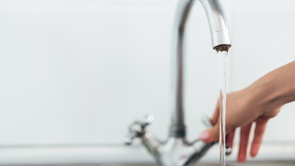 Wasserprivatisierung zerstört Lebensgrundlagen Eine Hand greift zum Wasserhahn und dreht diesen auf.